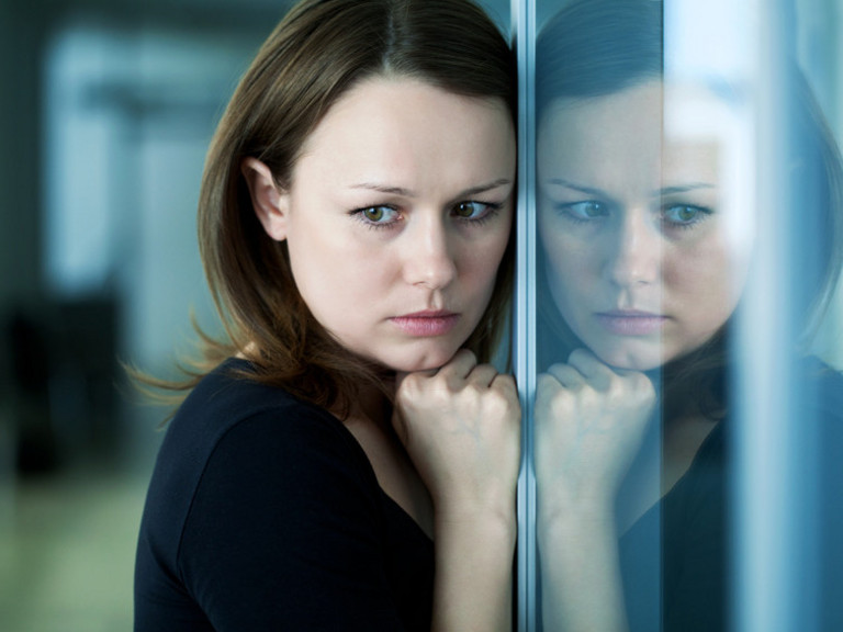 Betrübte Frau lehnt sich an gespiegelte Wand - Immanuel Beratung Betrübte Frau lehnt sich an gespiegelte Wand - Immanuel Beratung