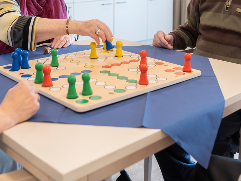 Auschnitt Hände und Brettspiel auf einem Tisch Auschnitt Hände und Brettspiel auf einem Tisch