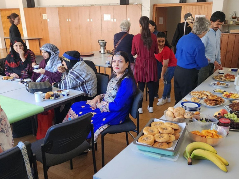 Buffet uns Frauen, die an Tischen sitzen und essen und trinken Buffet uns Frauen, die an Tischen sitzen und essen und trinken